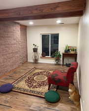 Interior space with hardwood / wood-style flooring and beam ceiling