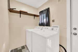 Clothes washing area with hardwood / wood-style flooring and washing machine and clothes dryer