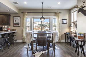 Dining area with a healthy amount of sunlight and dark hardwood / wood-style flooring