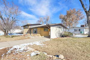 Back of house with a carport and a lawn