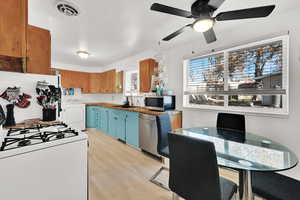 Kitchen with sink, stainless steel appliances, light hardwood / wood-style flooring, butcher block countertops, and washer / clothes dryer