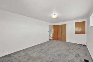 Empty room with carpet flooring and a textured ceiling