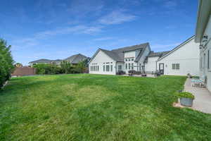 Rear view of property featuring a yard and a patio