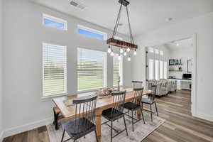 Dining area with hardwood / wood-style floors and vaulted ceiling