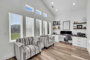 Office space with plenty of natural light, built in desk, and light hardwood / wood-style flooring