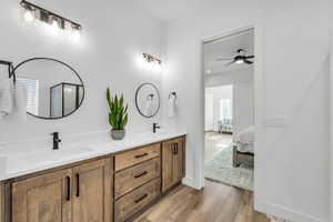 Bathroom featuring walk in shower, ceiling fan, vanity, and hardwood / wood-style flooring