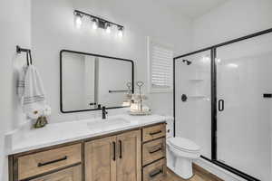 Bathroom featuring hardwood / wood-style floors, vanity, toilet, and walk in shower