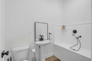 Bathroom featuring toilet and wood-type flooring