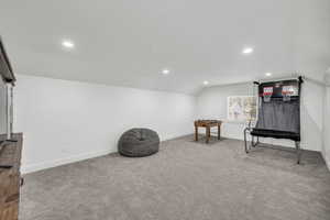 Sitting room featuring carpet flooring and vaulted ceiling