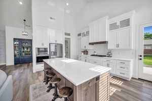 Kitchen with white cabinets, pendant lighting, stainless steel appliances, and a kitchen island