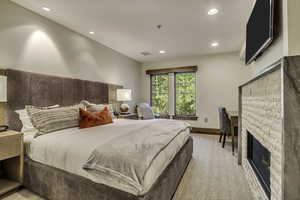 Bedroom with a stone fireplace