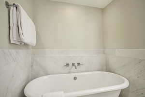 Bathroom with a bathing tub and tile walls