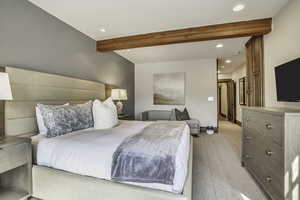 Carpeted bedroom featuring beamed ceiling