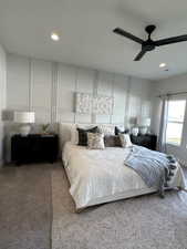 Carpeted bedroom featuring ceiling fan