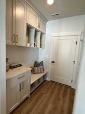 Mudroom featuring a textured ceiling and dark hardwood / wood-style floors