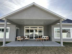 Rear view of property with a lawn, a patio area, and an outdoor hangout area