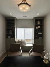 Living area with light hardwood / wood-style floors, built in features, and a textured ceiling