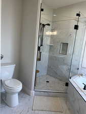 Bathroom featuring toilet and plus walk in shower