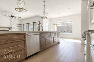 Kitchen with sink, hanging light fixtures, stainless steel dishwasher, ceiling fan, and light hardwood / wood-style floors