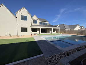 View of swimming pool with a lawn, an in ground hot tub, and a patio