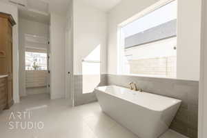 Bathroom featuring a bath and tile walls