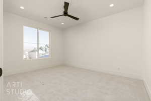 Empty room with ceiling fan and light colored carpet