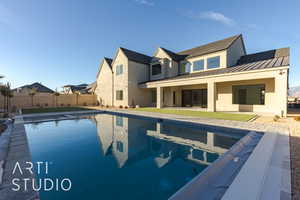 Rear view of house with a fenced in pool and a patio area