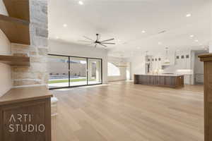 Unfurnished living room with ceiling fan, sink, and light hardwood / wood-style floors