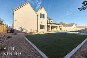 Back of property with a lawn, a patio area, and a fenced in pool