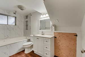 Full bathroom featuring toilet, wood-type flooring, vanity, and tiled shower / bath comboMIL bathroom in basement