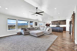 Living room with hardwood / wood-style flooring, a mountain view, ceiling fan, and lofted ceiling