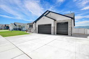 View of front of home with a front yard, a mountain view, and a garage