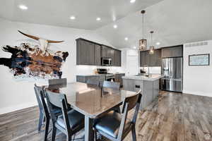 Dining space with hardwood / wood-style flooring, lofted ceiling, and sink