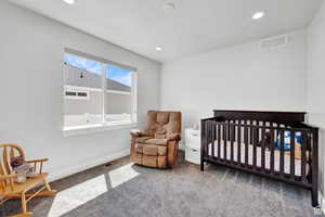 Bedroom featuring carpet flooring and a nursery area