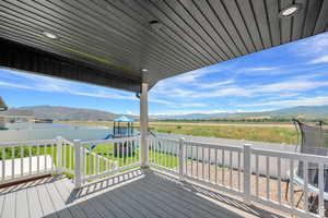 Wooden terrace featuring a mountain view, a trampoline, and a playground