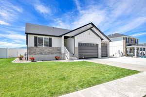 View of front of property with a front yard and a garage