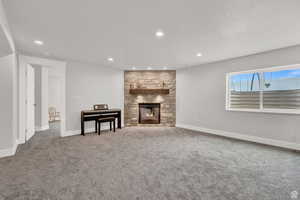 Living room with carpet flooring, a fireplace, and a textured ceiling