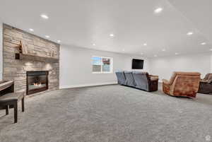 Living room with carpet floors and a stone fireplace