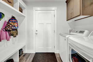 Laundry room featuring cabinets, independent washer and dryer, and hardwood / wood-style floors