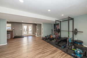 Workout area with hardwood / wood-style flooring and french doors