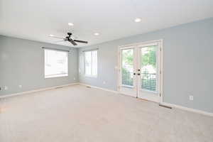 Spare room featuring baseboards, recessed lighting, light colored carpet, and plenty of natural light