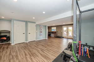 Exercise area with wood-type flooring and french doors