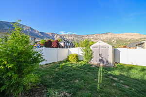 View of yard featuring a mountain view, a shed, and an outdoor structure