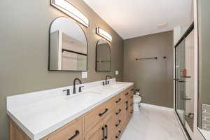 Bathroom with a textured ceiling, vanity, toilet, and a shower with door