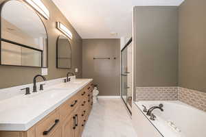 Full bathroom featuring shower with separate bathtub, vanity, a textured ceiling, and toilet