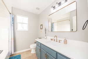 Full bathroom with shower / bath combination with curtain, vanity, and toilet