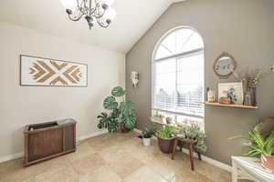 Living area featuring vaulted ceiling and a notable chandelier