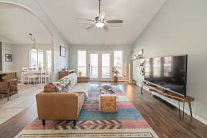 Living room featuring ceiling fan, dark wood-type flooring, and lofted ceiling