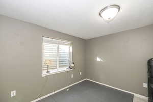 Tiled empty room featuring a textured ceiling