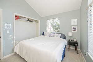 Carpeted bedroom featuring lofted ceiling